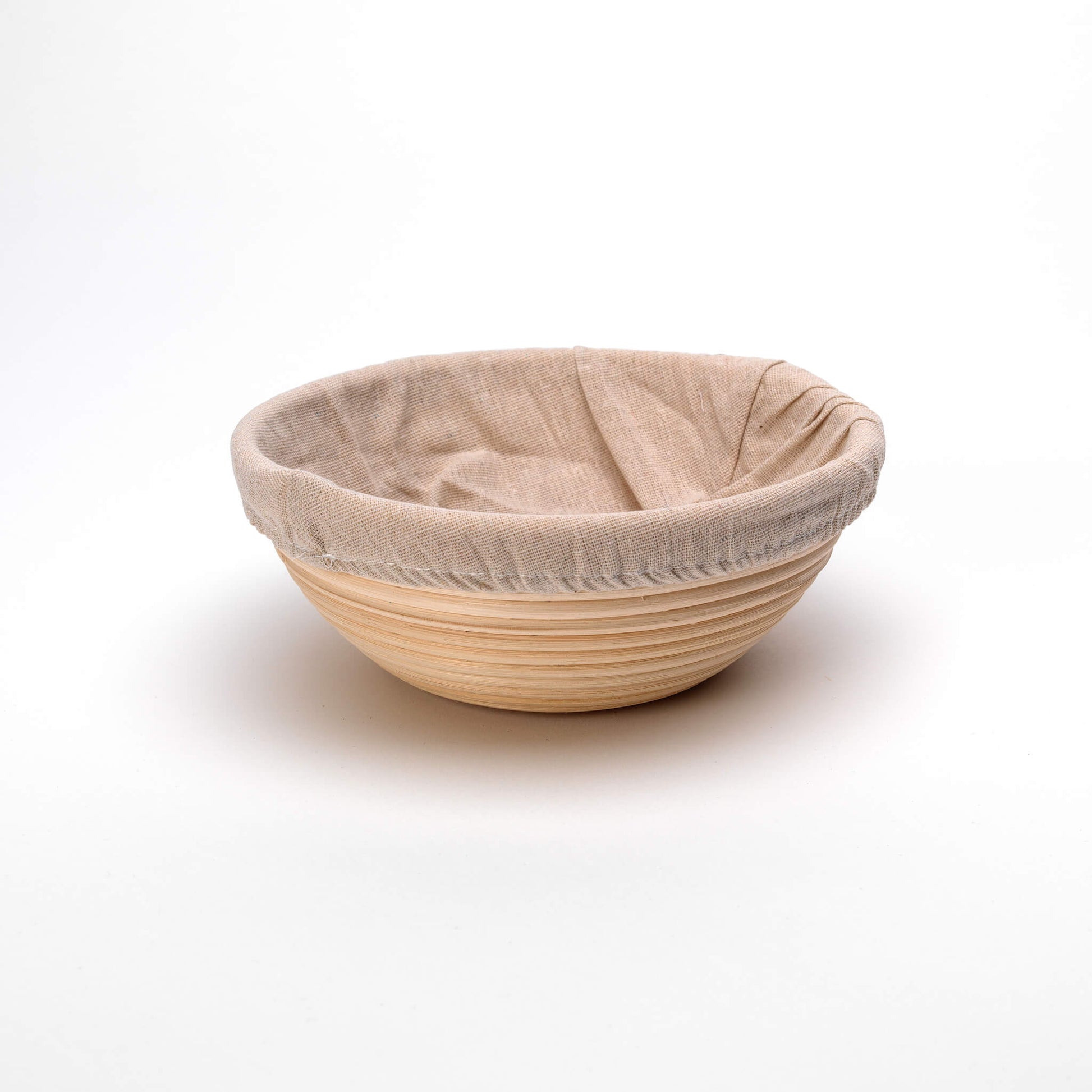 Banneton bread proofing basket with a cloth cover on a white background